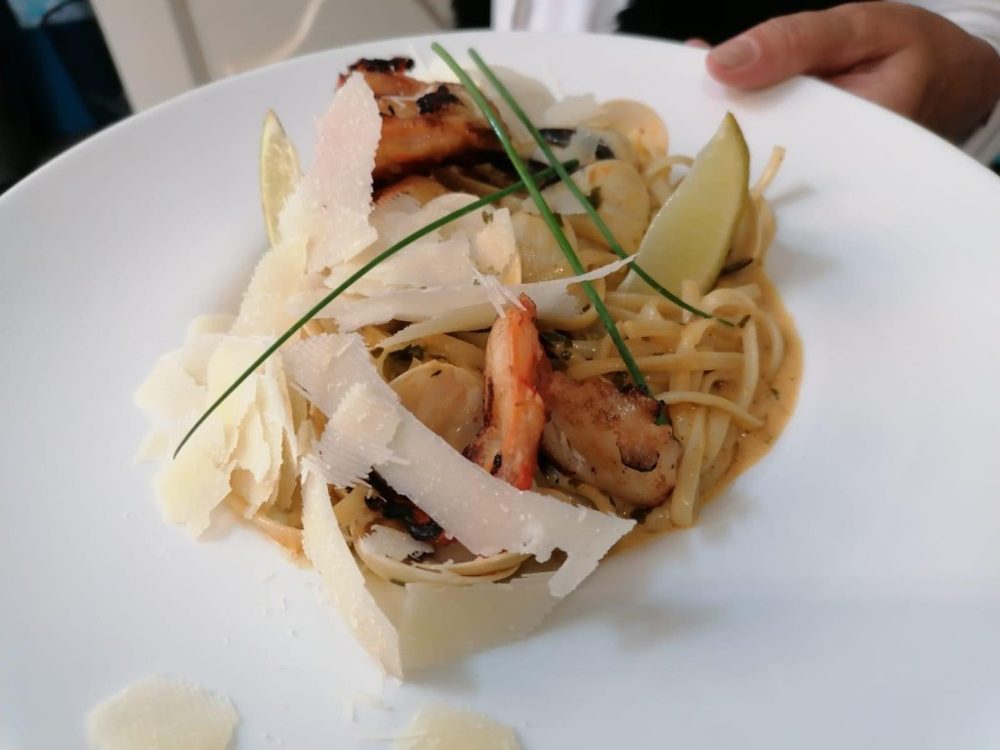 Des pâtes aux fruits de mer, parmesan et citron vert, dans une assiette creuse